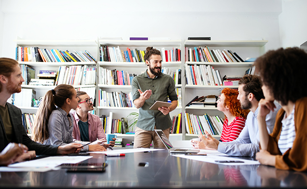 un homme debout face à un groupe de personnes en formation