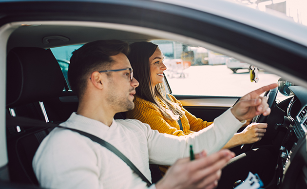 Moniteur auto-école avec une femme au volant dans une voiture